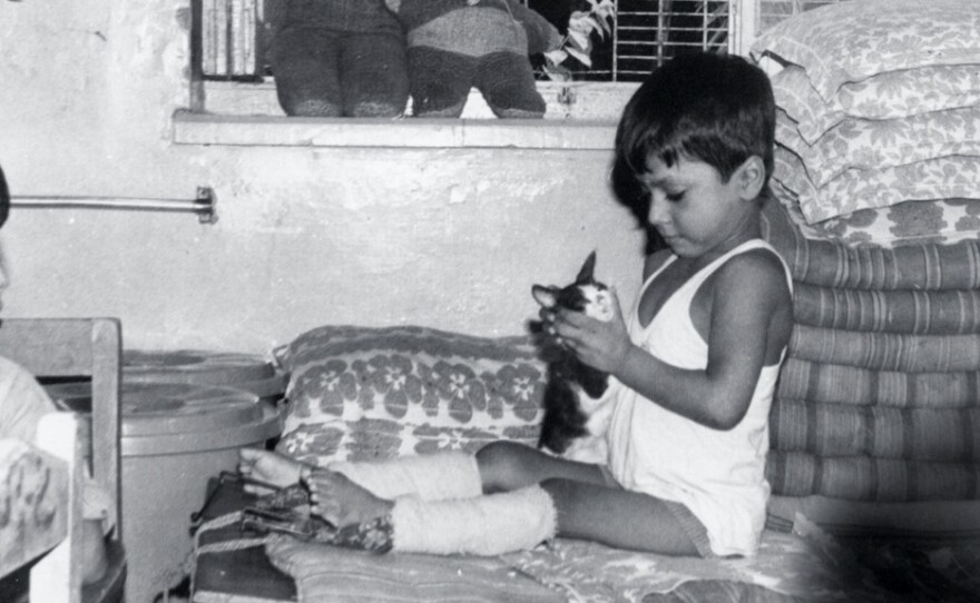 Lewis underwent a half-dozen corrective surgeries after contracting polio at 18 months. His treatment, under the care of Mother Teresa's Missionaries of Charity, included the straightening of his legs with weights strapped to his limbs for six months (pictured above).