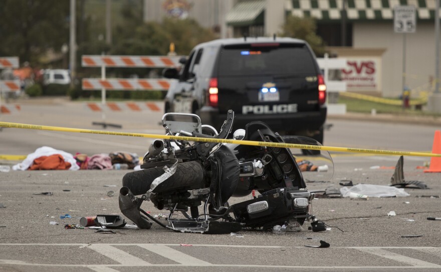 A wrecked police motorcycle lays on the scene after a suspected drunk driver crashed during the Oklahoma State University homecoming parade in Stillwater, Okla.