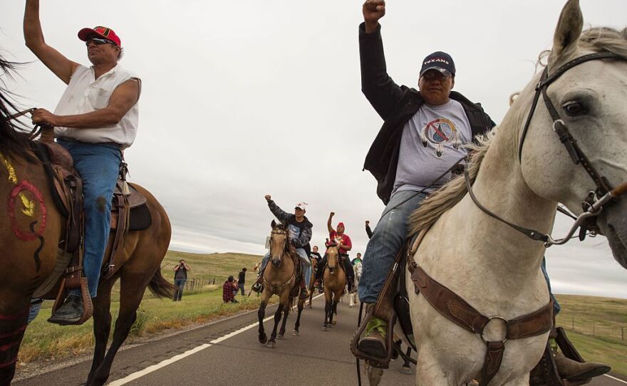 Protesters ride near the site of construction. The company building the pipeline says in court documents that it "is not destroying and has not destroyed any evidence or important historical sites."