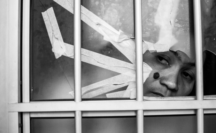 Lucia Cabral looks through a bullet hole in her door. She lives in the Alemao favela complex and says gunfire has become frequent in the past few days.