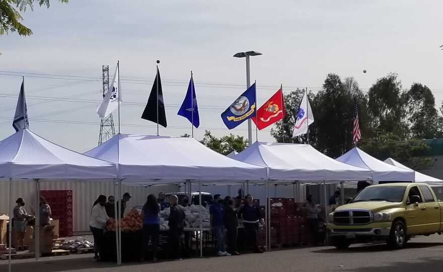 Armed Services YMCA tents with military flags flying on top shade volunteers and food that is being distributed for Thanksgiving in Murphy Canyon on November 18, 2021.