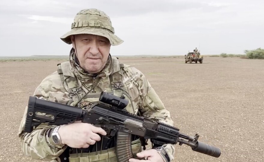 A screen grab captured from a video shared online shows Yevgeny Prigozhin, the founder of the Russian private security company Wagner, holding a rifle in a desert area while wearing camouflage in an unspecified location in Africa, Aug. 21.