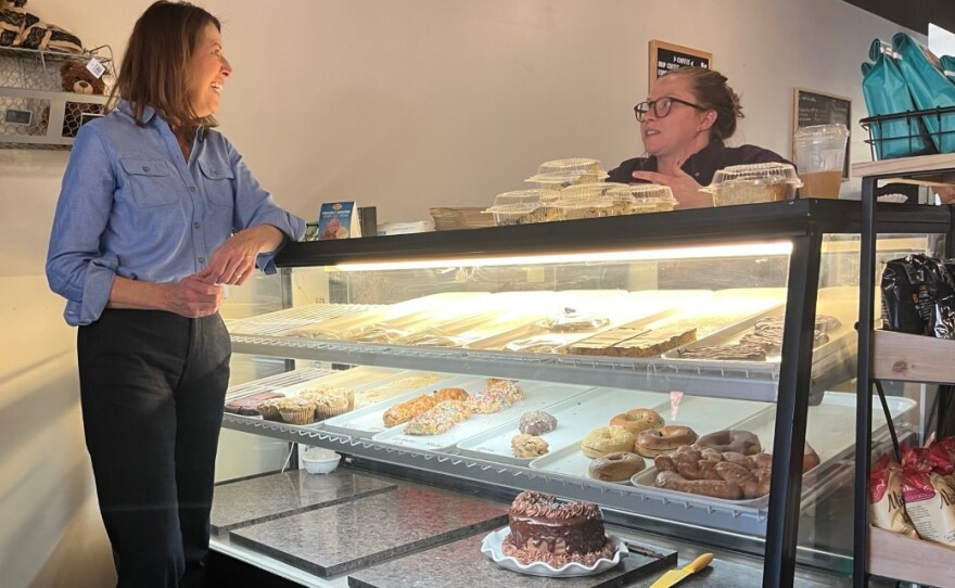 Iowa Democratic Rep. Cindy Axne speaks with barista Ali Meineke at a campaign stop in Panora, Iowa.