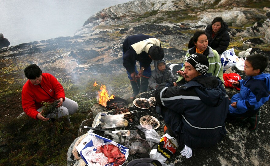 Arne Lange, a 39-year-old Inuit fisherman, and his family barbecue seal meat on an island near the village of Ilimanaq, Greenland in 2007.