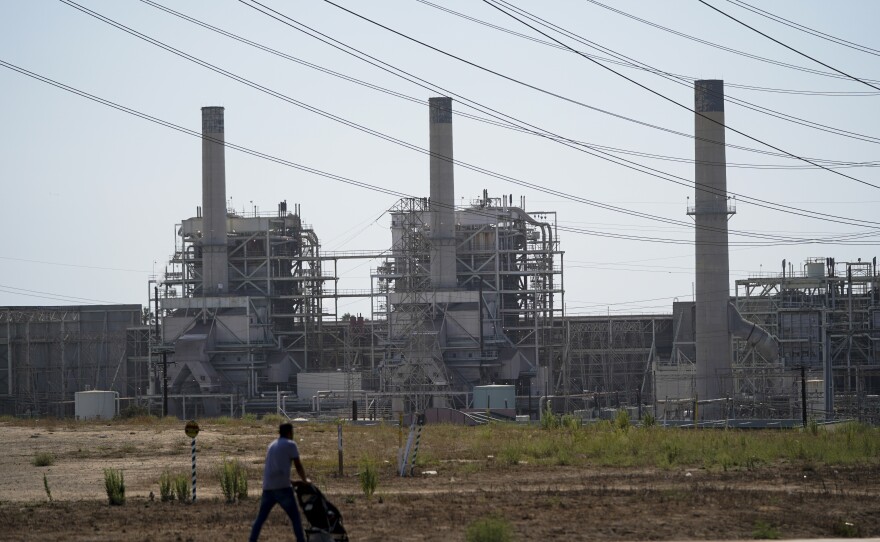 A man pushes a stroller near the AES power plant in Redondo Beach, California on Sept. 7, 2022.