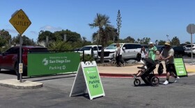 Visitors walk through the parking lot toward the entrance to the San Diego Zoo, July 28, 2025.