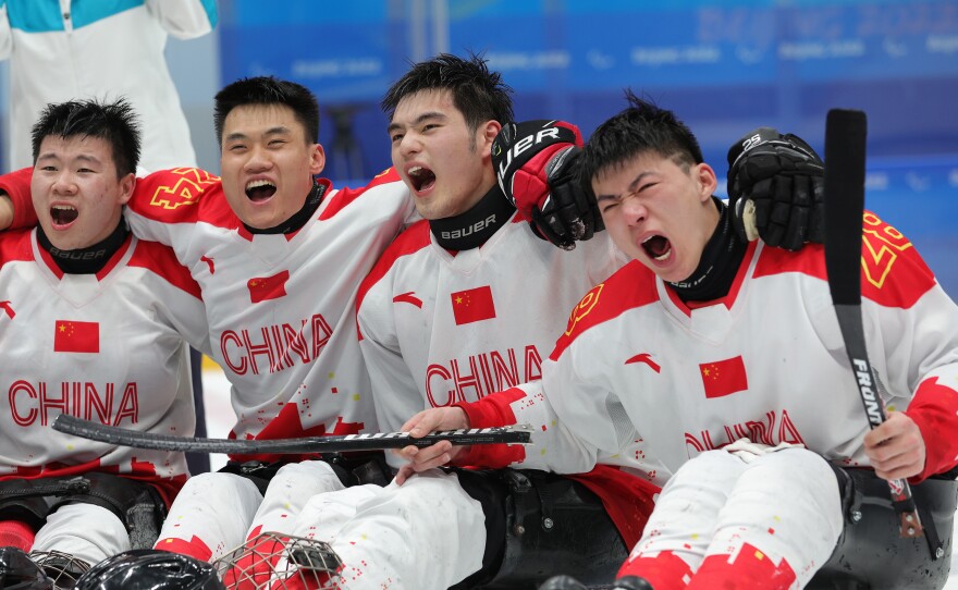 Members of Team China celebrate their win over South Korea during the para ice hockey bronze medal game on day eight of the Beijing 2022 Winter Paralympic.