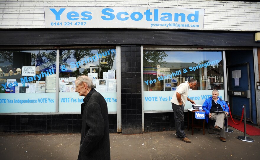 A pedestrian walks past the Yes Scotland campaign office in Glasgow on Aug. 19, ahead of the upcoming referendum on independence which will be held on Sept. 18. A majority of English people oppose Scotland continuing to use the pound if it votes to become independent.