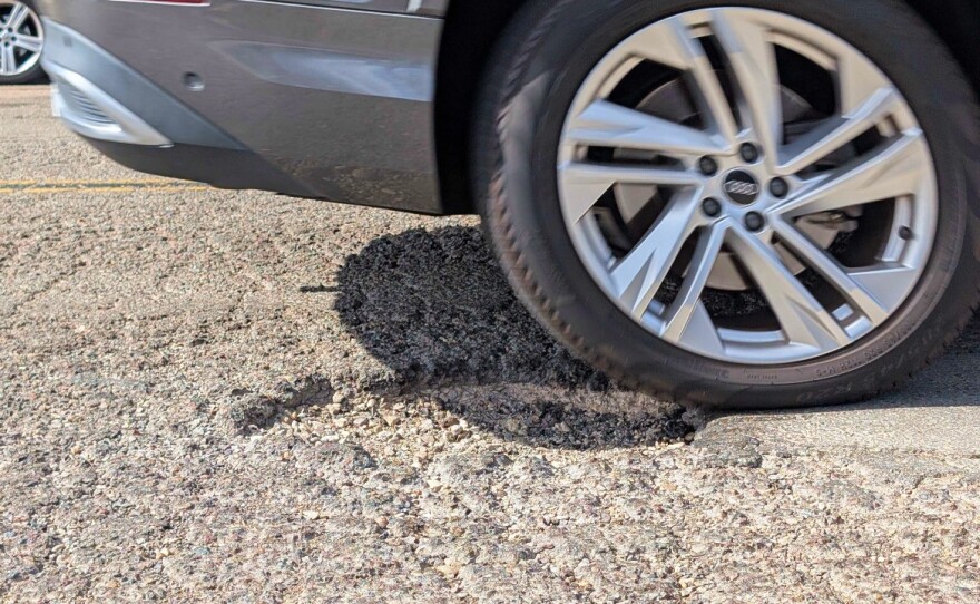 A car driving over a pothole on Ronson Road in Kearny Mesa on May 13, 2025.