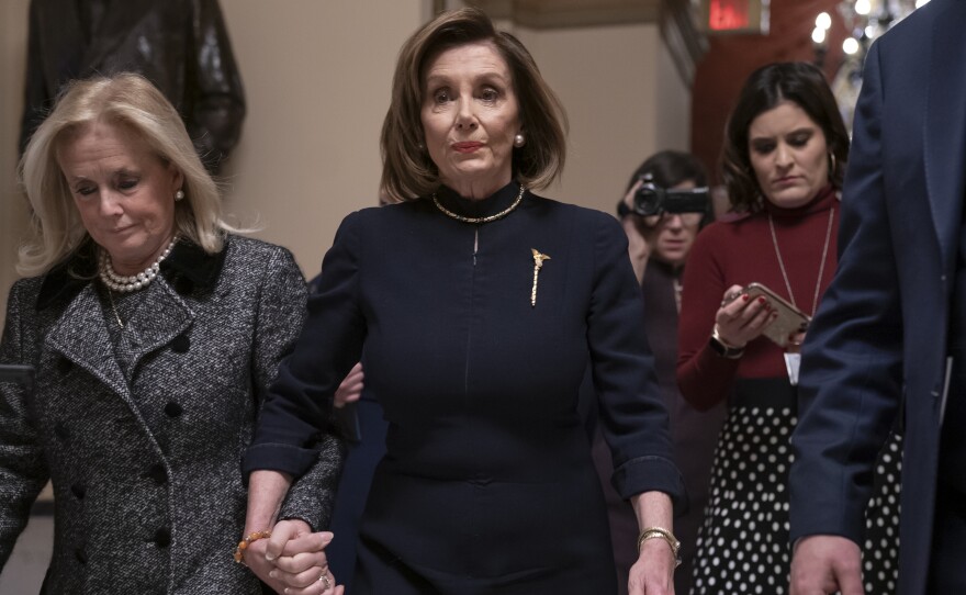 House Speaker Nancy Pelosi (D-Calif.) holds hands with Rep. Debbie Dingell (D-Mich.) as they walk to the chamber where the House begins debate on the impeachments charges against President Trump.