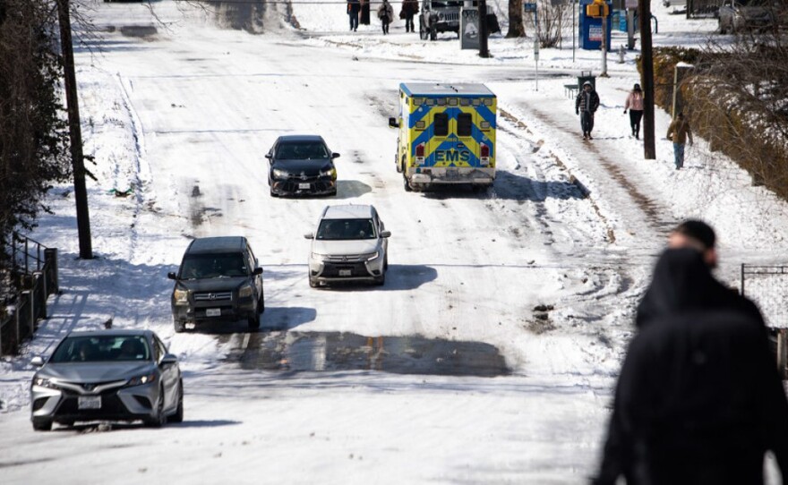 An ambulance drives on Oltorf Street in the Travis Heights neighborhood of South Austin on Tuesday.