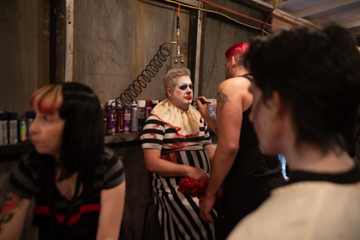 A makeup artist puts some finishing touches on Jonathan Sturch before sending him out to clown around on The Haunted Trail in Balboa Park on Sept. 25, 2025.