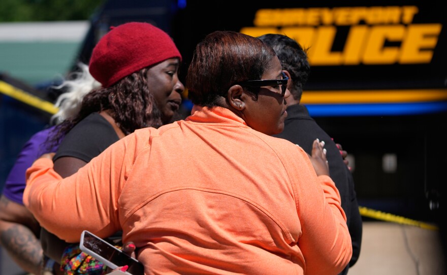 People console each other as they gather at the scene of a mass shooting in Shreveport, La., on Sunday.