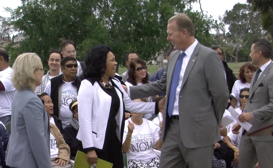 San Diego City Councilwoman Myrtle Cole and Mayor Kevin Faulconer smile at each other ahead of a press conference at Tooma Park in Cole's district, May 17, 2016.