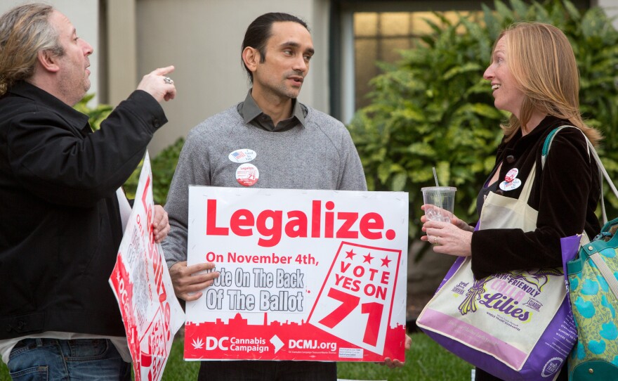 Volunteers with the DC Cannabis Campaign (left and center) talk to a voter about the ballot initiative to legalize marijuana on election day. The measure was approved, but its fate remains uncertain.