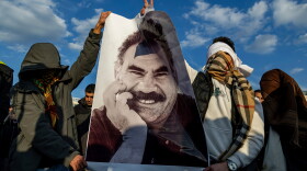 FILE - Youngsters hold a photograph of Abdullah Ocalan, the jailed leader of the militant Kurdish group, or PKK, in Diyarbakir, Turkey, Feb. 27, 2025.