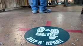 A sign on the ground reads "Wait here. Keep 6' apart" at Cali Baguette in Mira Mesa. Nov. 28, 2020.