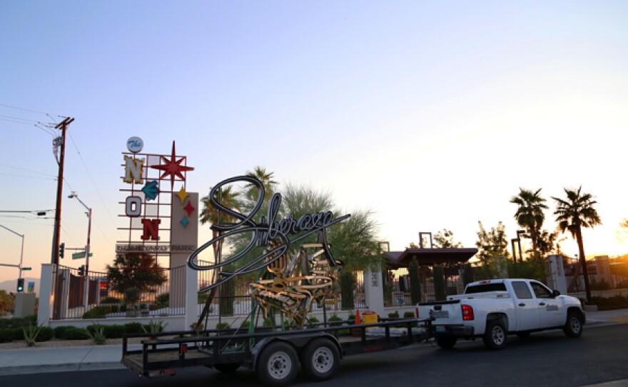 The restored Liberace sign on a truck bed as it is moved to the Neon Museum Boneyard.