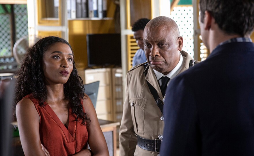 Camille Bordey (SARA MARTINS), Commissioner Selwyn Patterson (DON WARRINGTON) in a scene from DEATH IN PARADISE: Season 10.