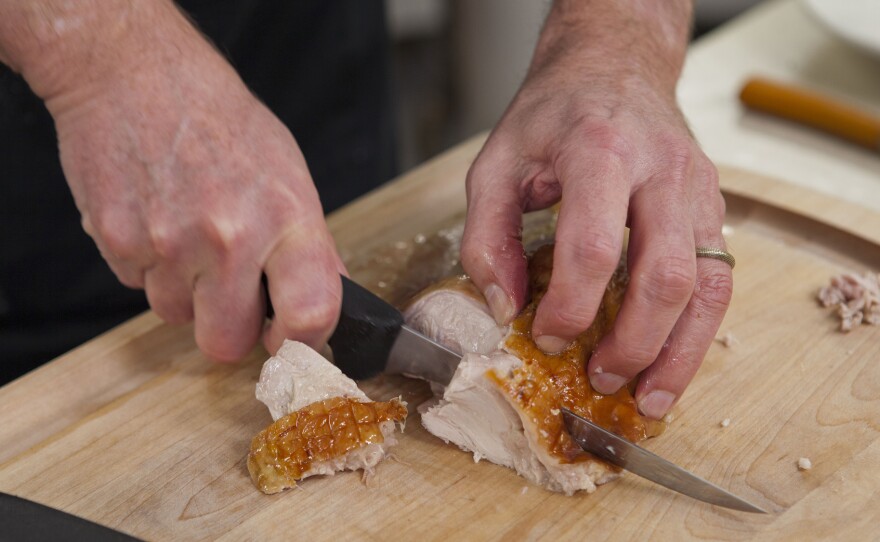 Chris Kimball slices up some cooked heritage turkey.