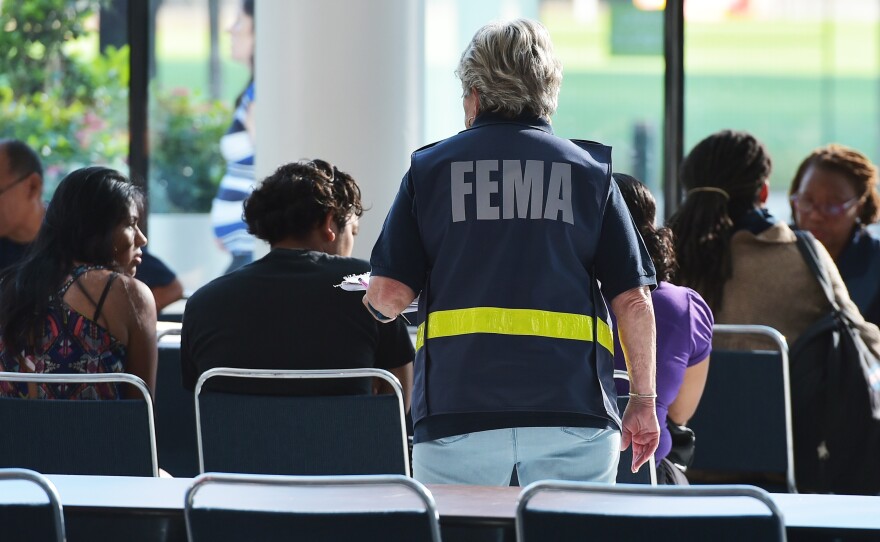 An official with the Federal Emergency Management Agency talks to people at Houston's George R. Brown Convention Center, which has been a shelter for evacuees from Hurricane Harvey, on Sept. 2.