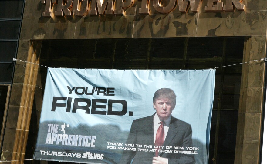 A sign advertising Trump's television show The Apprentice hangs at Trump Towers in New York City in 2004.