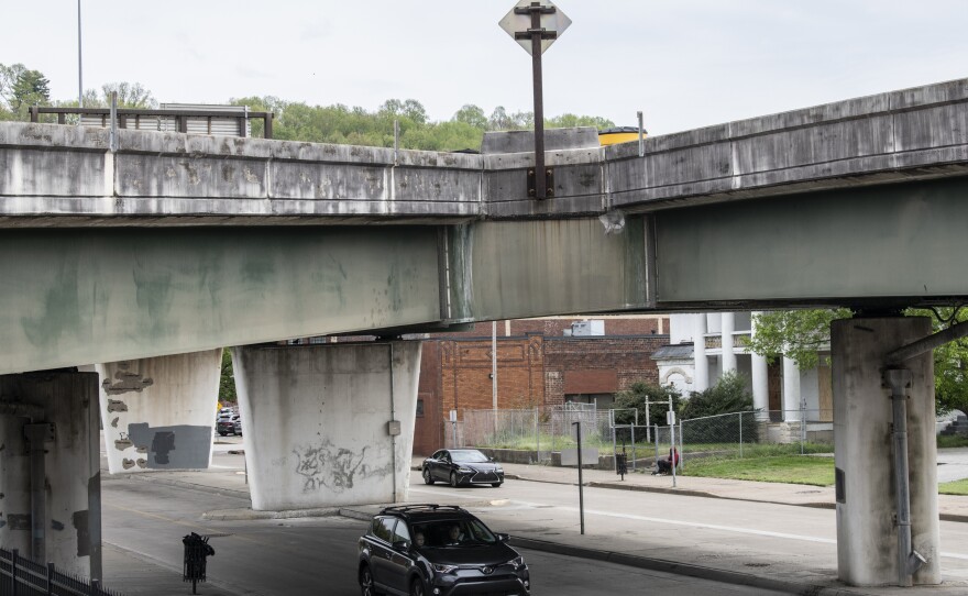 A car drives under an overpass in Charleston, W.Va., on Saturday. Classic infrastructure projects like roads and bridges are part of President Biden's infrastructure plan — but so are investments in health care and community caregiving.