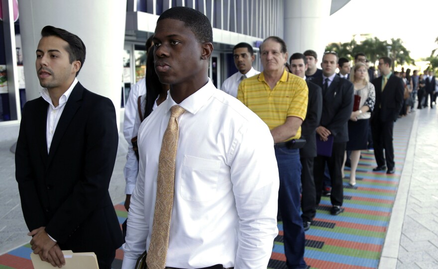 Luis Mendez, 23, left, and Maurice Mike, 23, wait in line at a job fair held by the Miami Marlins at Marlins Park in Miami on Oct. 23, 2013. The nation's unemployment rate slipped to 6.6 percent in January, but employers added only 113,000 jobs to their payrolls last month, the Bureau of Labor Statistics reported Friday.