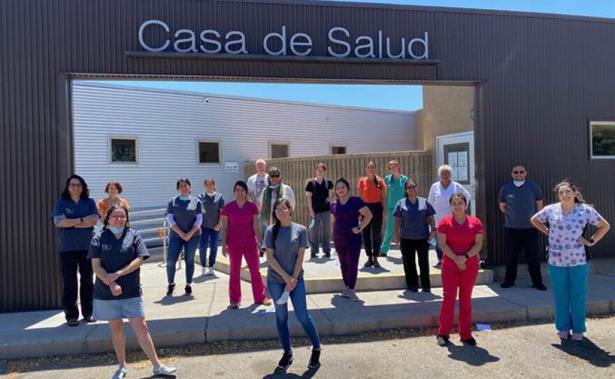 Casa de Salud clinicians, staff and health apprentices socially distance outside their New Mexico clinic. The facility is one of many social safety net clinics that haven't yet received pandemic-related funding and are now on the brink financially.