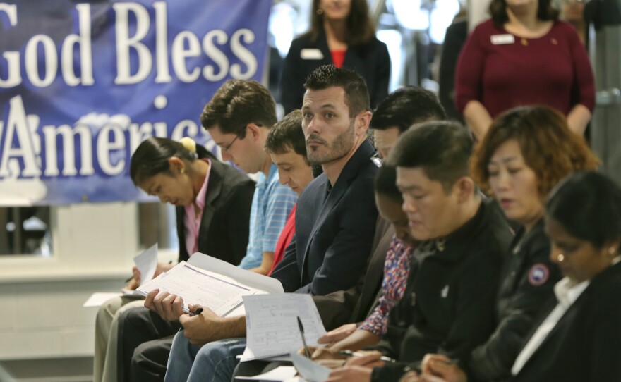 Newly naturalized U.S citizens complete voter registration forms in Bethel Park, Pa., in November 2017. The 2020 census will ask respondents whether they are citizens.