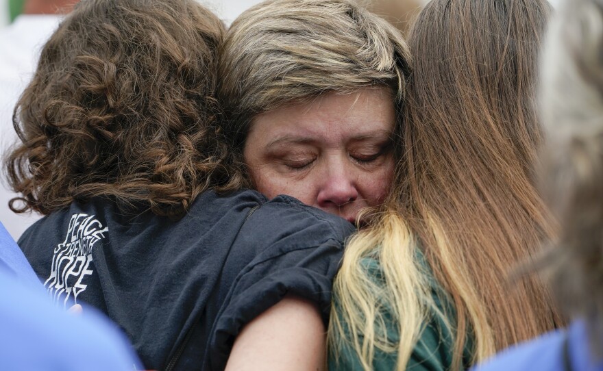 Karin LaBanca comforts two survivors of the mass shooting at Sandy Hook Elementary school after a man tried and failed to rush the stage during the second March for Our Lives rally.