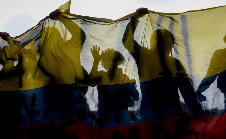 Demonstrators hold a Colombian flag in Plaza Bolívar in the centre of the capital, Bogotá, on 1 May 2021.