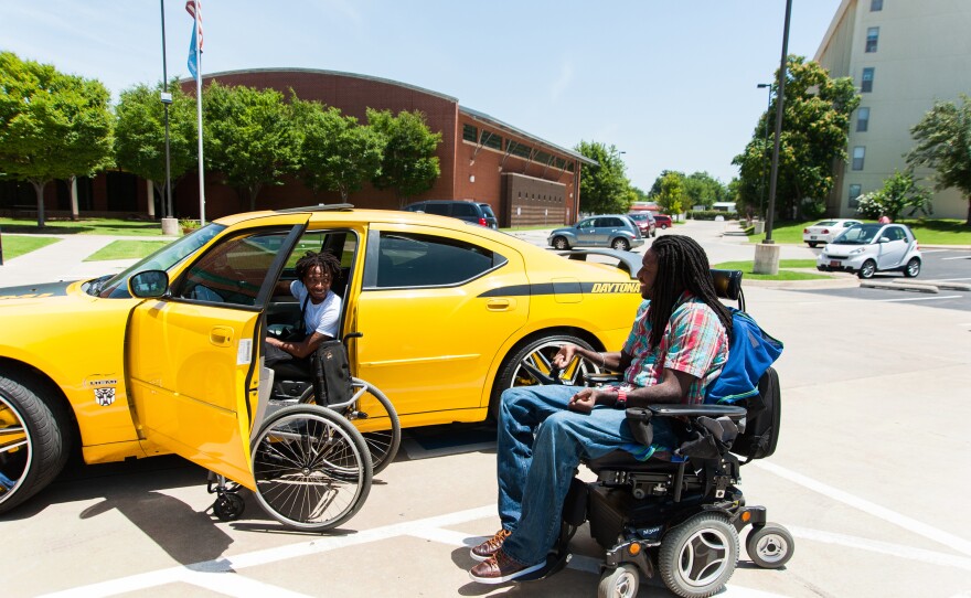 Nnaka runs into his friend Aaron Million in the parking lot of Tulsa's Center for Individuals with Physical Challenges.