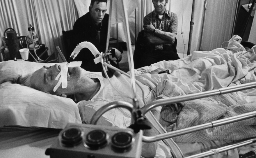 Jess Bishop takes his last breaths while his sons — also coal miners — keep vigil in Logan County, W.Va., in 1976. Since 2010, more than 4,000 coal miners have been diagnosed with advanced black lung disease.