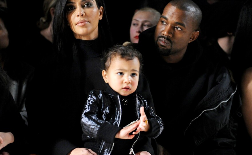 Kim Kardashian, North West and Kanye West attend a fashion show in February.