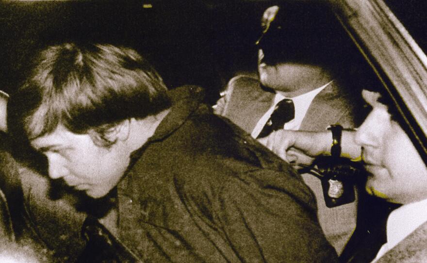 John Hinckley Jr. is escorted by police in Washington, D.C., following his arrest after shooting and seriously wounding president Ronald Reagan on March 30, 1981.