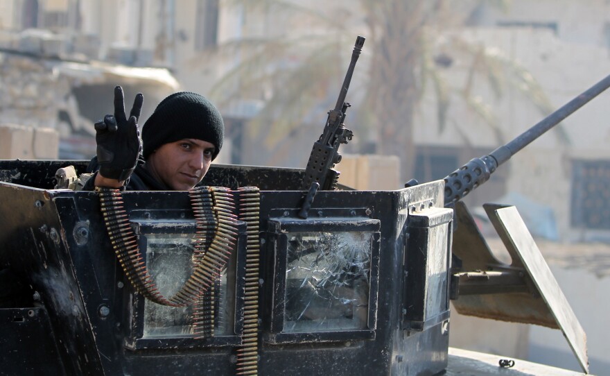 A member of Iraq's elite counterterrorism service flashes the "V" for victory sign Tuesday in Ramadi, the capital of Iraq's Anbar province. Iraq's prime minister says the extremist group will be pushed out of Iraq in 2016.