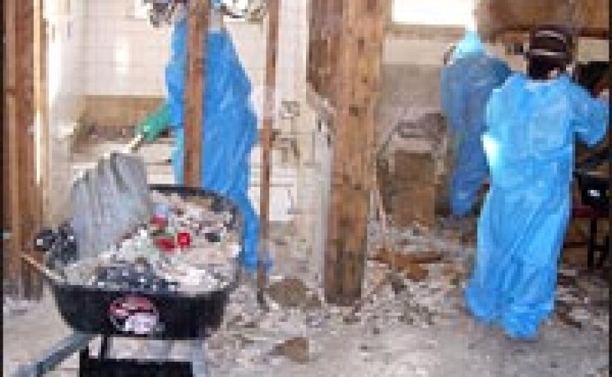 A crew working for Acorn, a community-housing group, tears out moldy flooring and drywall in a home in New Orleans' Lower Ninth Ward.