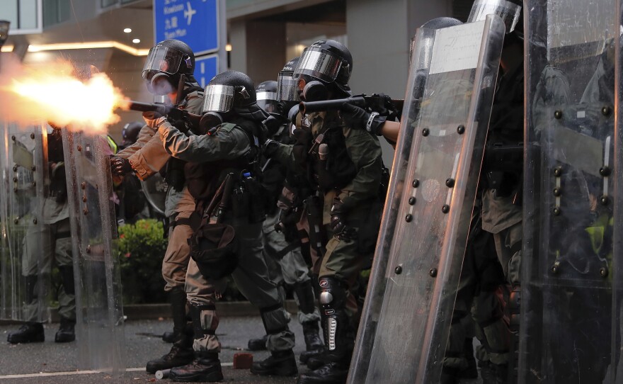 Riot police fire tear gas at protesters in Hong Kong on Aug. 25.