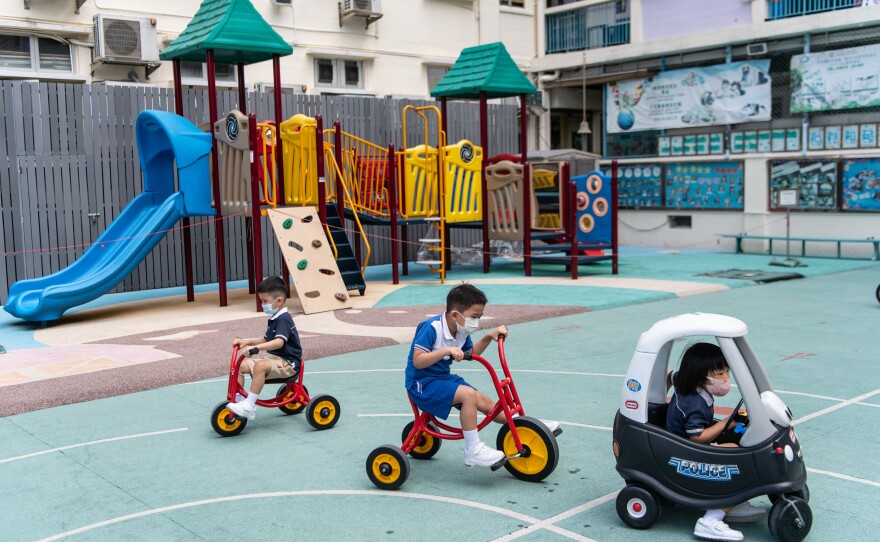 Primary school students enjoy recess at a distance from each other, with masks in place.