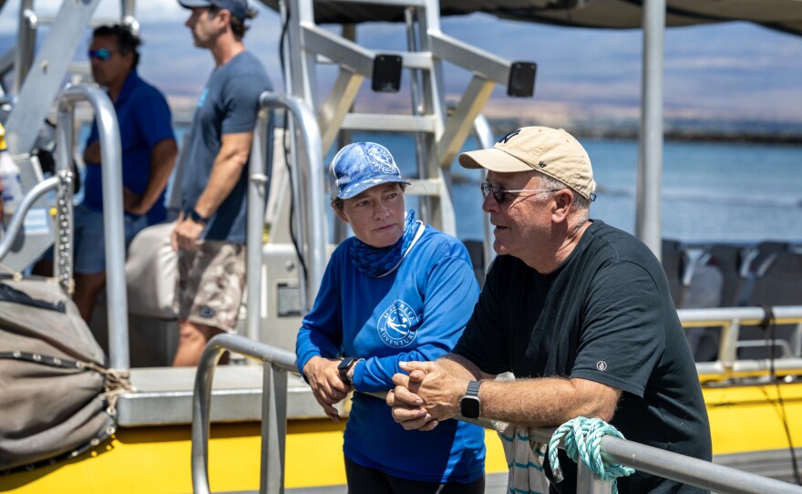 John Picard, right, talks to Jennifer Kogan. Kogan, center, offered to give Picard and his wife a boat ride to Lahaina to be reunited with their daughter since they are unable to drive on the closed road to Lahaina.