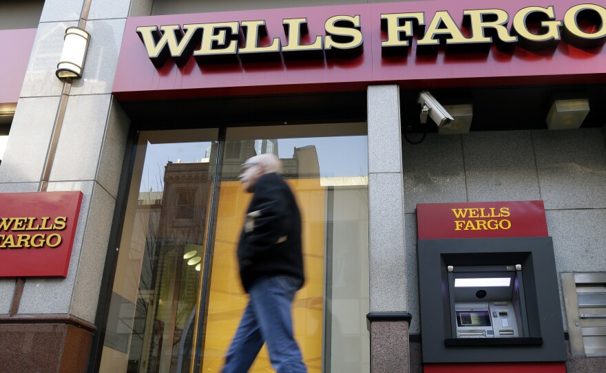 A man walks past a Wells Fargo branch in Philadelphia. The banking company says it wants to make good by its customers, but figuring out how to do that will be a tall task.