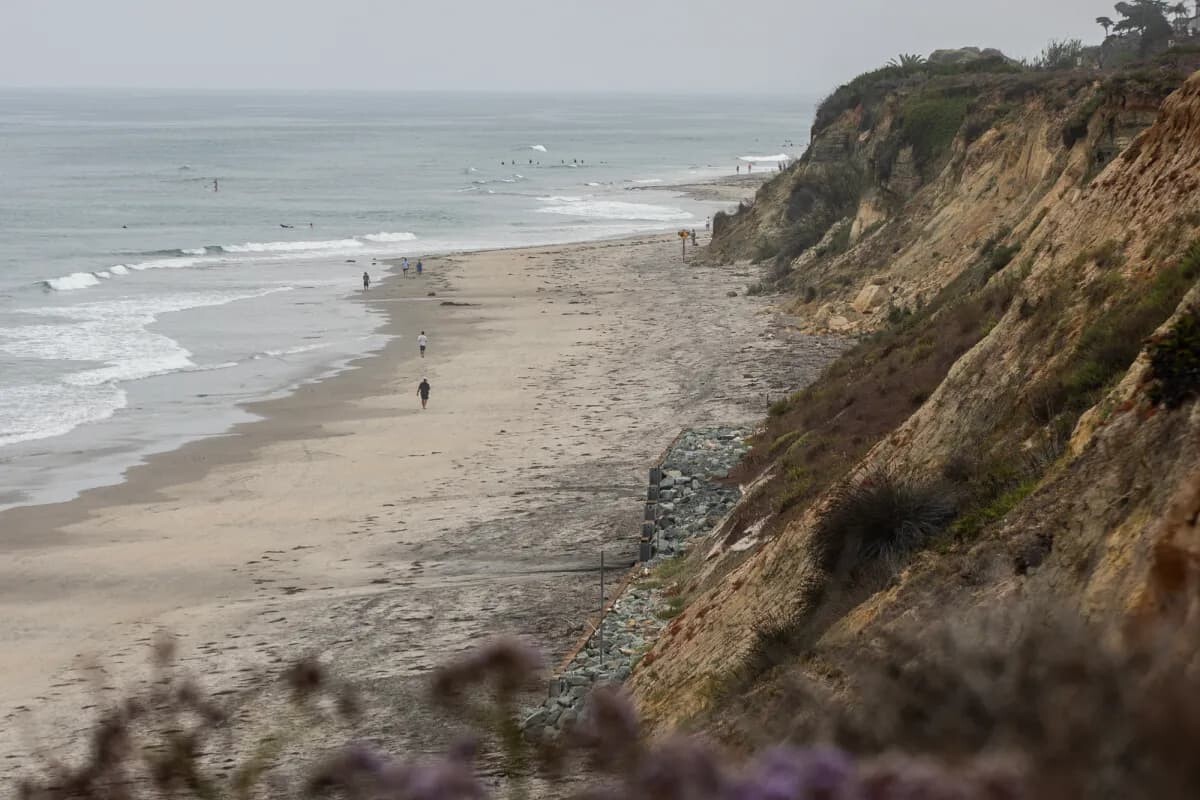 People walk along the bluffs in Del Mar on July 25, 2023.