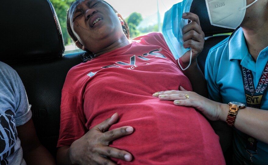 Midwife Merissa Tuping, right, assists Risa Calibuso, who is in labor, with her breathing while the reporter drove her to the nearest hospital. Because of the Philippine law against home birth, the midwife would not deliver the child in Calibuso's residence.