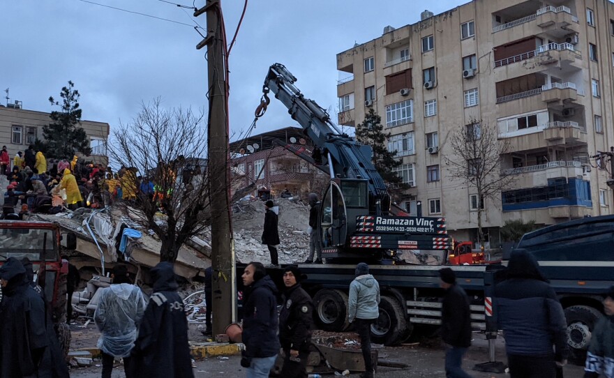 Rescue workers and volunteers search for survivors in the rubble of a collapsed building, in Sanliurfa, Turkey, on Monday.