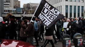 Protesters hold a Black Lives Matter flag as they march for Patrick Lyoya, a Black man who was fatally shot by a police officer, in downtown Grand Rapids, Mich.