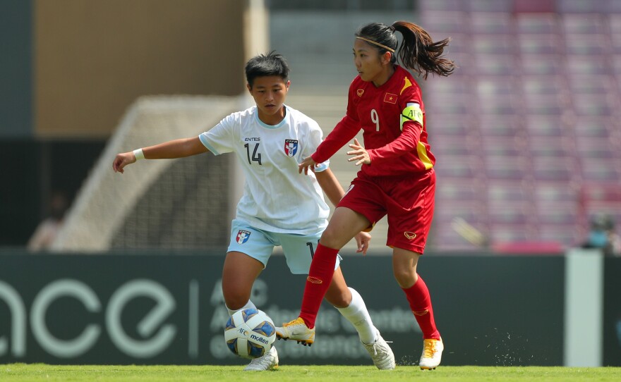Huynh Nhu of Vietnam, in red, controls the ball during a Women's Asian Cup play-off game in February.