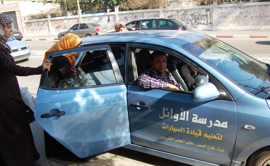 Students enter a car with instructor Abdel Nasser el-Bobbo in the passenger seat. To get around Hamas' recent crackdown on male instructors who are alone with female students, schools ask students to ride along with other learners.