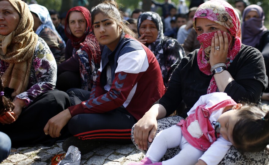 Migrants listen to a speaker talk to them about their future as they rest in a stadium while waiting to cross from Turkey's western border into Greece and Bulgaria on Wednesday.