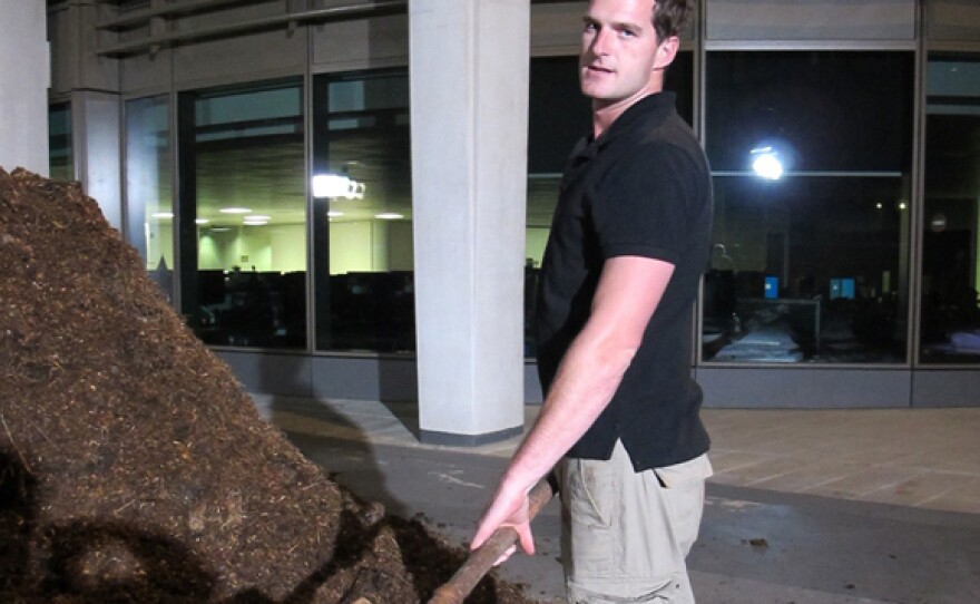 Host Dan Snow cleaning horse manure.